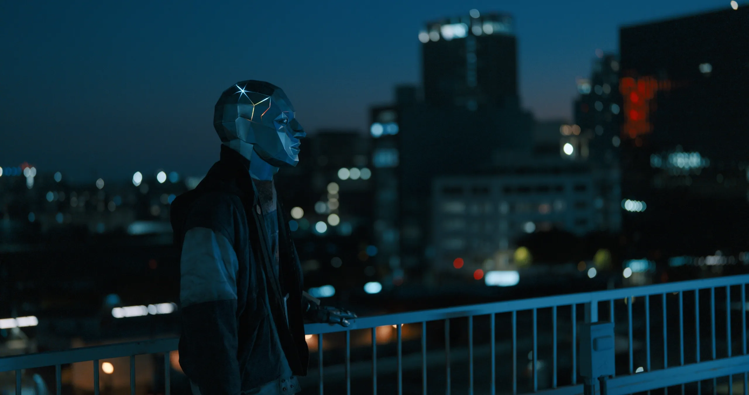 A figure in a mirrored mask on a rooftop above a city at night, from SIIGA